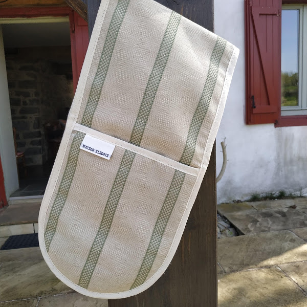 Sage striped double oven gloves hanging in front of a Basque house