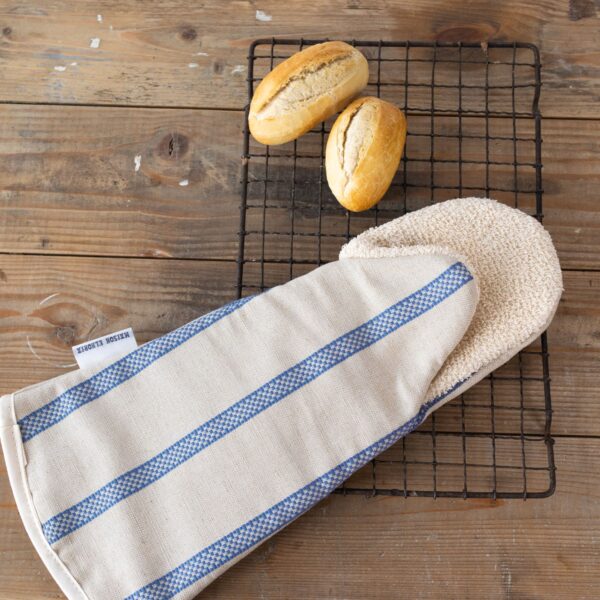 Long oven gauntlet glove natural with blue stripes on a wooden table with bread