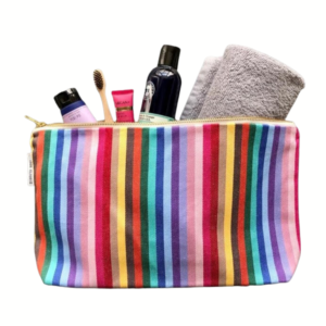 large rainbow make up bag with assorted toiletries comin out on a clear background